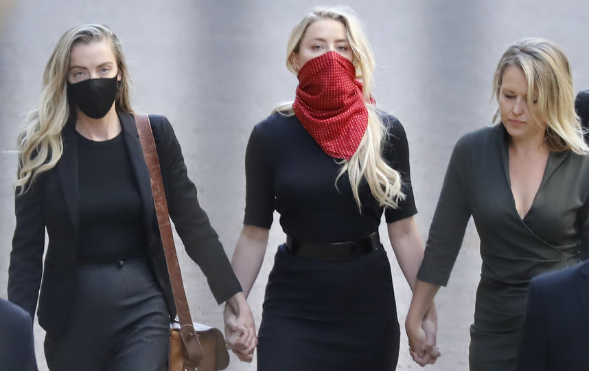 Эмбер прибыла вместе со своей сестрой Уитни (слева) и адвокатом (справа). Фото AFP