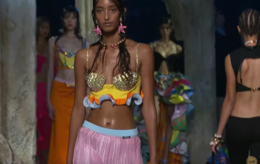 О подводной тематике также говорят принты и украшения в виде ракушек. Фото Versace, Скриншот Youtube