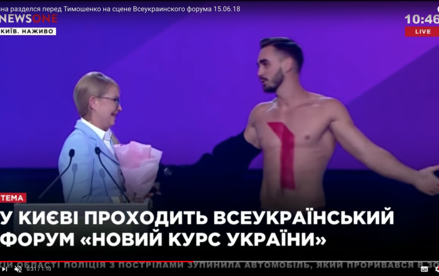 На кадрах видно, что молодой мужчина поднимается на сцену и вручает Тимошенко цветы. Фото Скриншот Youtube