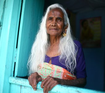 Тамильская женщина ждет семью с работ на чайной плантации