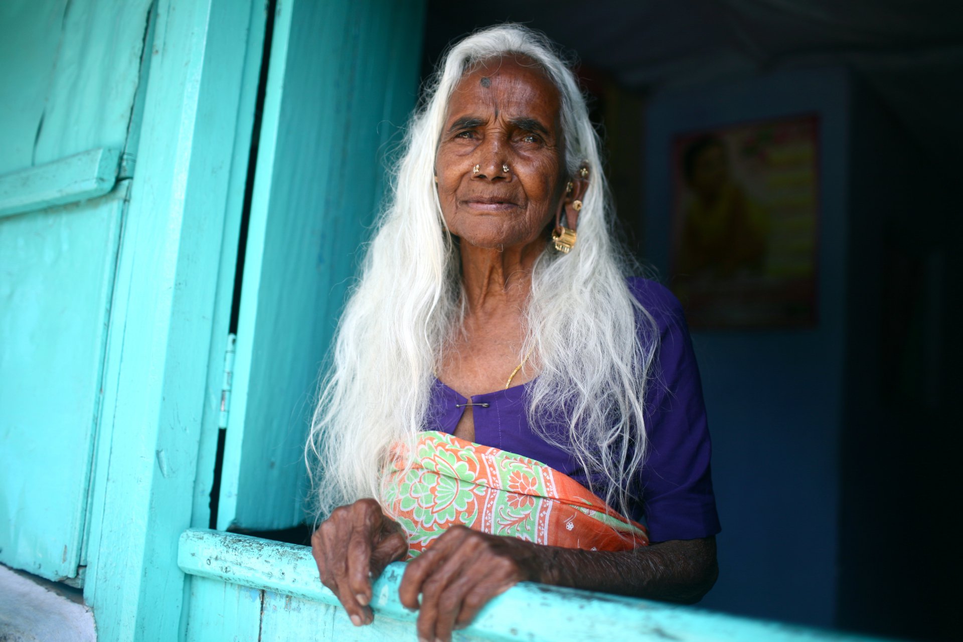 Тамильская женщина ждет семью с работ на чайной плантации