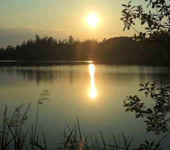 Лучи восходящего солнца скользят по речной глади.