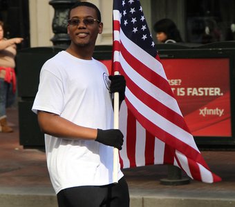 Молодой человек несет флаг США, как символ свободы