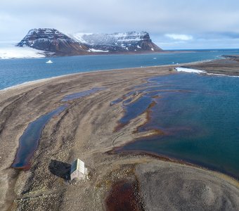 Домик "Убежище Эйры" на острове Белл архипелага Земля Франца-Иосифа с видом на остров Мейбел.
