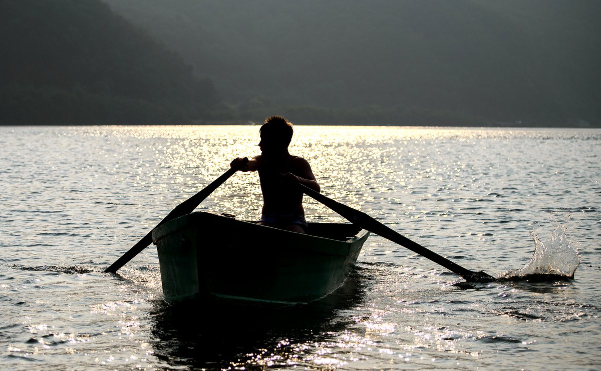 Оттолкнул лодку. Лодка на реке. Беженцы на лодках. Весло от лодки. Толкают лодку.
