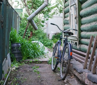 Старый велосипед у дома в деревне