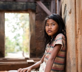 Камбоджийская девочка в стенах древних храмов Ангкора