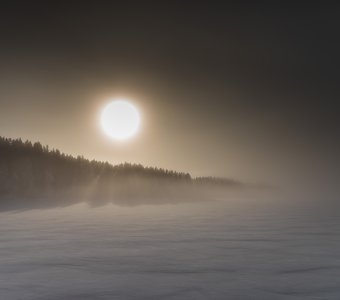 Восход солнца над озером в тумане