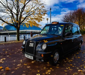 Глазго, Шотландия. Осенний вид на набережную реки Клайд. Английское такси и жёлтые листья