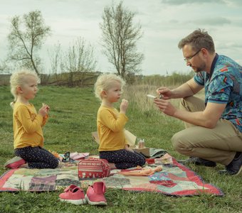 Заботливый отец со своими детьми на пикнике.