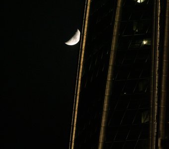 Луна скрывается за небоскребом