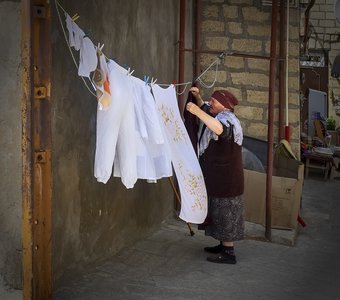 Пожилая женщина, развешивающая белье. Дербент, Дагестан.
