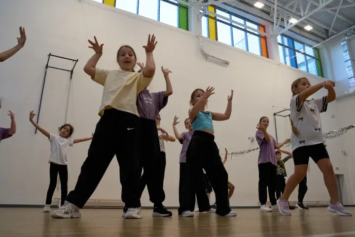 Юные спортсмены выполняют танцевальную связку с поднятыми руками