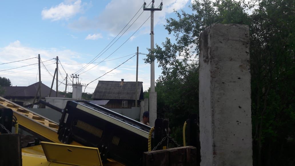 Строительная площадка под забор: установленные бетонные столбы, щебень и доски на грунте, вдалеке видна техника (Нижний Тагил, Черемушки)