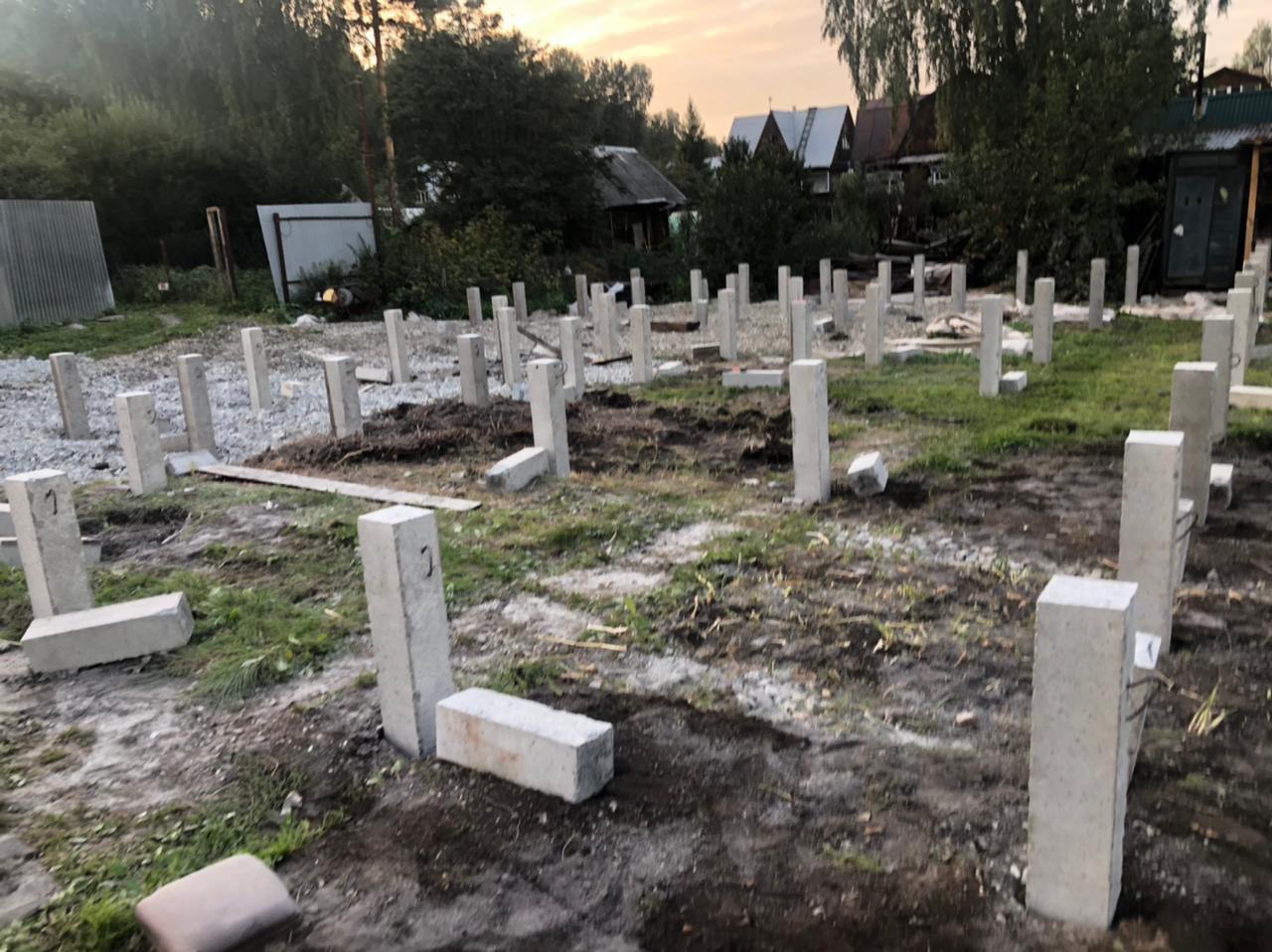 Свайный фундамент под жилой дом, Екатеринбург Чусовской тракт — бетонные столбы на участке, вид на закате
