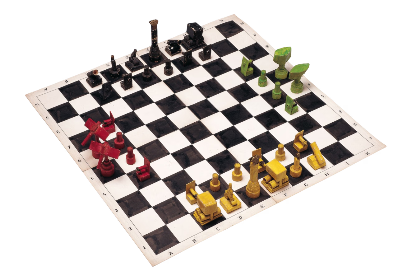 Необычная шахматная доска с красочными, абстрактными фигурами красного, черного, зеленого и желтого цвета на клетчатой ​​доске.