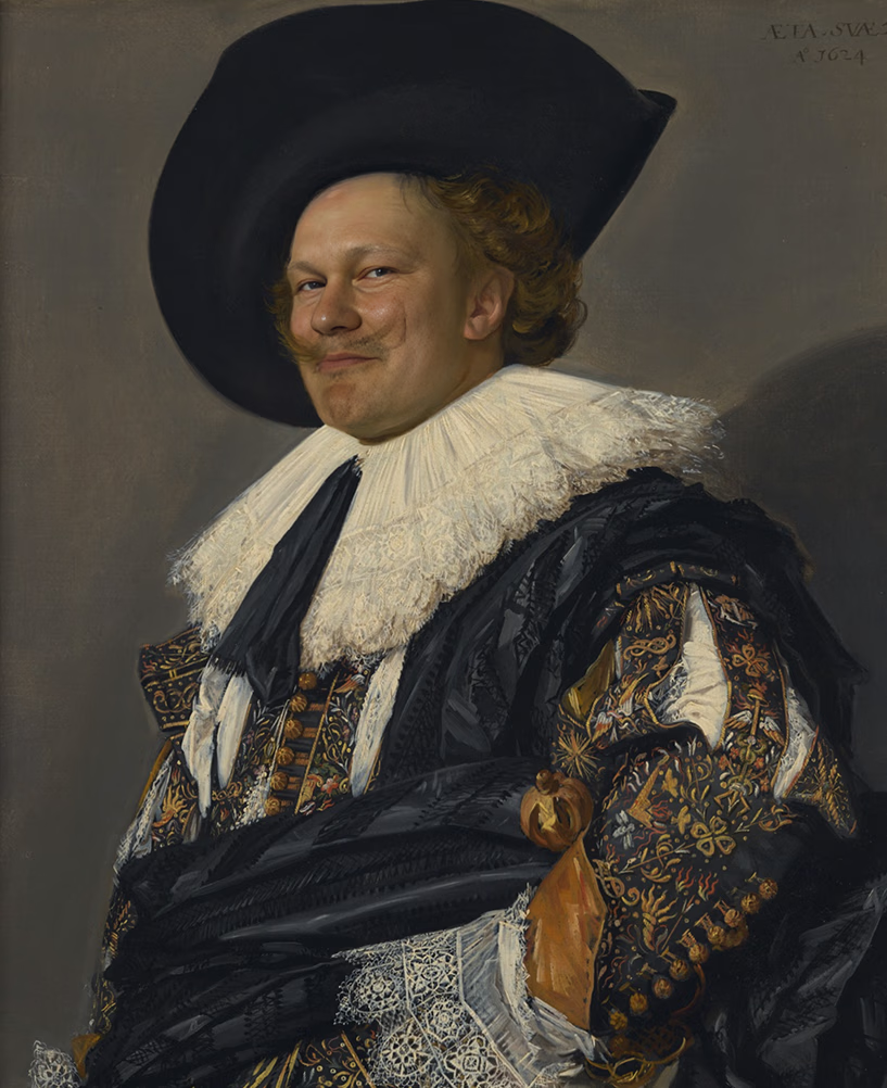 Олег Рогов в образе вельможи XVII века: богатое одеяние, широкополая чёрная шляпа, кружевной воротник, вышитые рукава, уверенная улыбка – игривое и элегантное настроение.