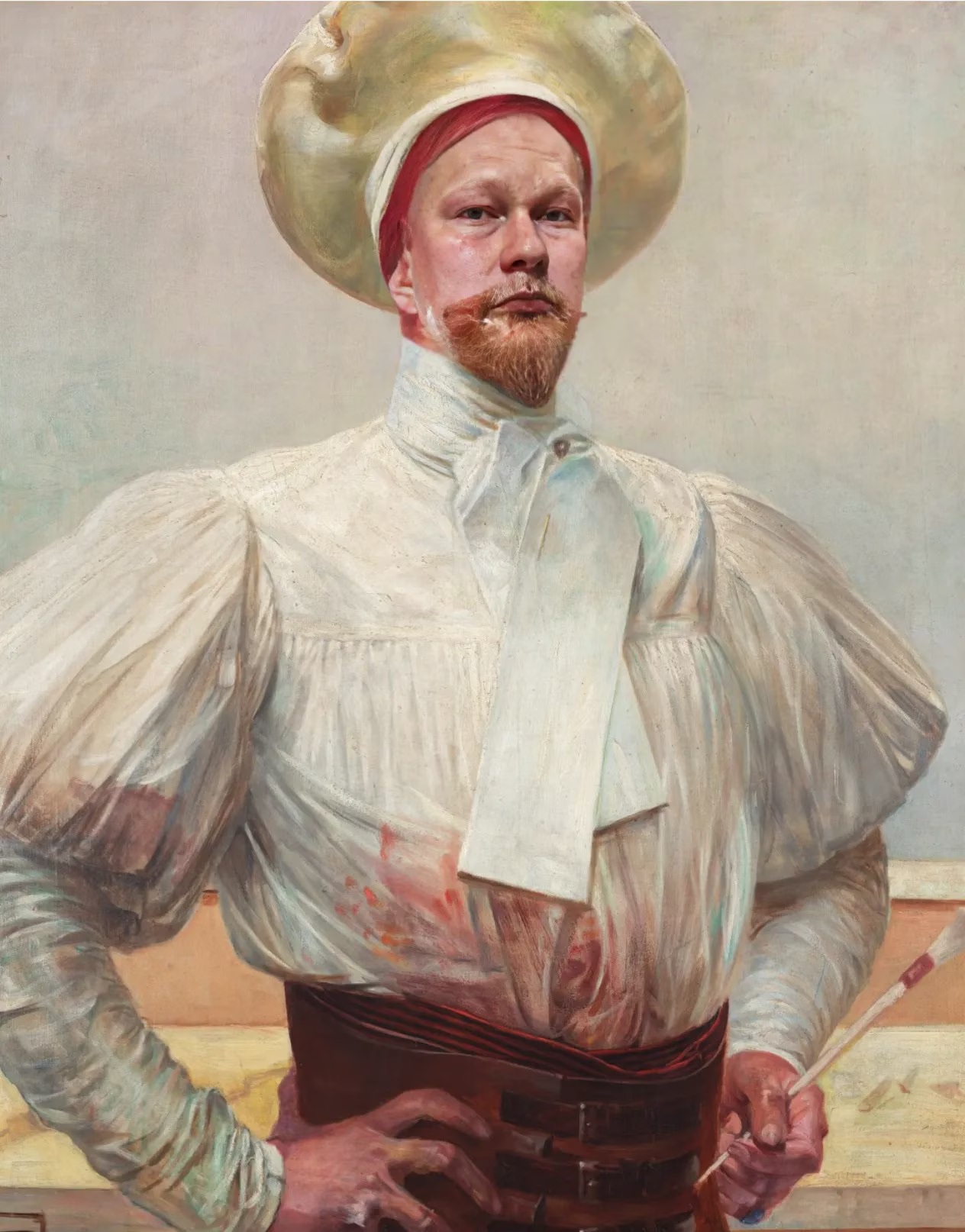 Портрет Олега Рогова в образе художника: белый костюм с рукавами-буфами, большая шляпа, в руке кисть, серьёзное выражение лица, передающее креативность.